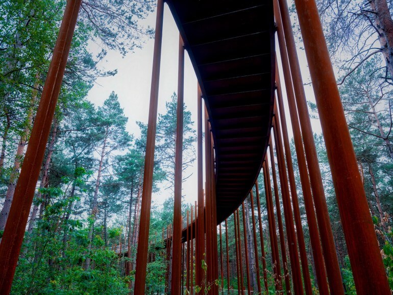Cette construction se veut écologique puisqu'elle utilise des colonnes en acier corten, symbolisent les troncs droits des pins